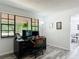 Bright office features hardwood floors, a large window overlooking the landscape, a desk, computer, and office equipment at 2580 Se 157Th Lane Rd, Summerfield, FL 34491