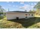 The backyard features green lawn, sliding glass door entry and freshly painted, light gray siding at 315 Sw 140 Ave, Ocala, FL 34481