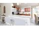 Open kitchen with a granite countertop island, wooden cabinets, and stainless steel refrigerator at 340 Oak Track Loop, Ocala, FL 34472