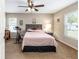 Bedroom with neutral walls, carpet, ceiling fan, light pink bedding, and natural light from windows at 3887 Sw 156Th Pl, Ocala, FL 34473