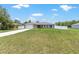 A house featuring a large lawn, a long driveway, and a two-car garage, all enhanced by a clear sky at 3887 Sw 156Th Pl, Ocala, FL 34473