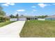 A single-story home featuring a well-kept lawn, a long driveway leading to a two-car garage, and a tidy front yard at 3887 Sw 156Th Pl, Ocala, FL 34473