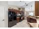 Spacious kitchen with tile floors, dark wood cabinets, and modern black appliances at 3887 Sw 156Th Pl, Ocala, FL 34473