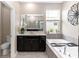 Bright bathroom with a black vanity, white countertop, and large soaking tub at 5248 Red Coral Cir, Mount Dora, FL 32757