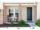 A welcoming front porch features rocking chairs, brick accents, and a stylish black front door at 5248 Red Coral Cir, Mount Dora, FL 32757