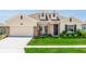 Charming single-Gathering home featuring a well-manicured lawn, complemented by stone accents and a two-car garage at 5248 Red Coral Cir, Mount Dora, FL 32757