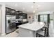 Modern kitchen with black cabinetry, stainless steel appliances, and a large quartz island with bar seating at 5248 Red Coral Cir, Mount Dora, FL 32757