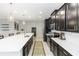 Spacious kitchen with long quartz island, black cabinetry, and stainless steel appliances, perfect for cooking and entertaining at 5248 Red Coral Cir, Mount Dora, FL 32757