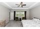 Bright main bedroom with tray ceiling, ceiling fan, carpet, and natural light at 5248 Red Coral Cir, Mount Dora, FL 32757