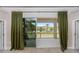 View from inside the house to the patio, featuring lush greenery and natural light at 5248 Red Coral Cir, Mount Dora, FL 32757