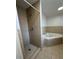 Bathroom with tiled shower, jacuzzi tub and tiled flooring at 5525 Se 43Rd Ct, Ocala, FL 34480