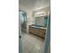 Bathroom featuring double sink vanity, tiled floors, and a shower/tub combo at 5525 Se 43Rd Ct, Ocala, FL 34480