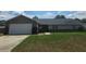 Charming single-story home featuring a brick facade, attached garage, and well-maintained lawn at 5525 Se 43Rd Ct, Ocala, FL 34480