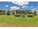 Lush backyard with a screened-in lanai, showcasing meticulous landscaping and green grass at 5634 Sw 91St Ave, Ocala, FL 34481