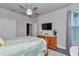 Comfortable bedroom featuring a ceiling fan, wood dresser, television and a large window for natural light at 5634 Sw 91St Ave, Ocala, FL 34481