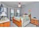 Bright bedroom with a wooden bed frame, ceiling fan, and large windows for natural light at 5634 Sw 91St Ave, Ocala, FL 34481