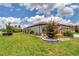 House with a beautifully landscaped yard, featuring colorful flowers and healthy green grass at 5634 Sw 91St Ave, Ocala, FL 34481