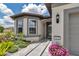 Close-up of a home's entrance with an inviting doorway, surrounded by decorative plants and stone pathway at 5634 Sw 91St Ave, Ocala, FL 34481