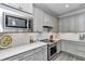 Contemporary kitchen features stainless steel appliances, a subway tile backsplash, and gray cabinetry at 5634 Sw 91St Ave, Ocala, FL 34481