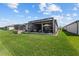 Beautiful backyard featuring a screened lanai, lush green grass, and a well-manicured lawn at 5728 Sw 90Th Court Rd, Ocala, FL 34481
