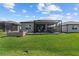 Spacious backyard with a stone fire pit area, a screened-in lanai, and a well-maintained lawn at 5728 Sw 90Th Court Rd, Ocala, FL 34481