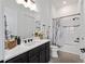 Well-lit bathroom featuring a dark vanity, white countertops, and a shower-tub combo at 5728 Sw 90Th Court Rd, Ocala, FL 34481