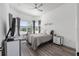 Well-lit bedroom with a large window, ceiling fan, and dresser at 5728 Sw 90Th Court Rd, Ocala, FL 34481