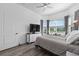 Comfortable bedroom featuring wood-look flooring, large windows, and a flat screen television at 5728 Sw 90Th Court Rd, Ocala, FL 34481
