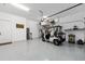 Spacious garage featuring epoxy flooring, overhead storage, and a golf cart with ample room for vehicles at 5728 Sw 90Th Court Rd, Ocala, FL 34481