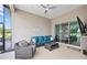 Enclosed lanai with ceiling fan, wicker furniture, TV, and view at 5728 Sw 90Th Court Rd, Ocala, FL 34481