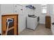 Well-lit laundry room featuring tile floors, a washer and dryer, and built-in shelving for convenient storage at 5728 Sw 90Th Court Rd, Ocala, FL 34481