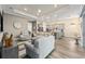 Open-concept living room and kitchen featuring wood floors and gray decor with plentiful seating at 5728 Sw 90Th Court Rd, Ocala, FL 34481
