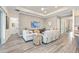 Bright living room with a tray ceiling, wood floors, comfortable seating, and a wall-mounted television at 5728 Sw 90Th Court Rd, Ocala, FL 34481
