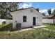 Back exterior featuring a well-kept white exterior and a small patio area at 719 Nw 8Th St, Ocala, FL 34475