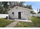View of the back of the house, showing a white exterior, dark door, and air conditioning unit at 719 Nw 8Th St, Ocala, FL 34475