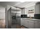 Stainless steel refrigerator compliments light gray cabinets and granite countertops at 719 Nw 8Th St, Ocala, FL 34475