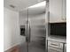 Stainless steel refrigerator with water dispenser next to light gray cabinets and granite countertops at 719 Nw 8Th St, Ocala, FL 34475