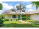 A charming single-Gathering home featuring a light yellow exterior with light blue trim and a well-maintained front yard at 8 Juniper Pass Way, Ocala, FL 34480