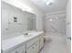 Well-lit bathroom with a large mirror, vanity, and tiled shower-tub combo at 8710 Sw 91St Pl # B, Ocala, FL 34481