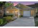 Charming yellow single-story home featuring a covered front porch, one-car garage, and well-maintained landscaping at sunset at 8710 Sw 91St Pl # B, Ocala, FL 34481