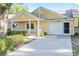 Charming yellow single-story home featuring a covered front porch, one-car garage, and well-maintained landscaping at 8710 Sw 91St Pl # B, Ocala, FL 34481