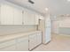 Bright kitchen featuring white cabinets, tile floors, and a view into the neutral living room at 8710 Sw 91St Pl # B, Ocala, FL 34481