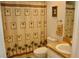 Bathroom with a toilet, vanity, and shower with patterned curtain at 8735 Sw 192Nd Court Rd, Dunnellon, FL 34432
