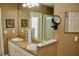 Dual sink bathroom vanity with white cabinets and a lighted makeup mirror at 8735 Sw 192Nd Court Rd, Dunnellon, FL 34432