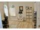 Bedroom with arched window, desk with chair, white storage unit with storage cubes, and wood-look floors at 8735 Sw 192Nd Court Rd, Dunnellon, FL 34432