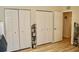 Bedroom featuring wood-look floors, three white closets, and a view into the hallway at 8735 Sw 192Nd Court Rd, Dunnellon, FL 34432