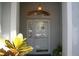 Inviting front entrance with a decorative transom window, and a yellow and green potted plant at 8735 Sw 192Nd Court Rd, Dunnellon, FL 34432