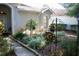 Beautifully landscaped front yard with manicured bushes, plants, decorative wrought iron, and a sidewalk at 8735 Sw 192Nd Court Rd, Dunnellon, FL 34432