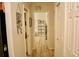Hallway with wood-look floors leading to another room with white shelving unit and a collage picture frame on the wall at 8735 Sw 192Nd Court Rd, Dunnellon, FL 34432