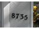 Close-up of the house number '8735' in black numerals against a textured wall at 8735 Sw 192Nd Court Rd, Dunnellon, FL 34432